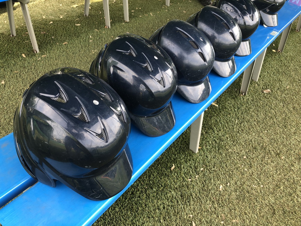 ベンチに並べられた野球のヘルメット