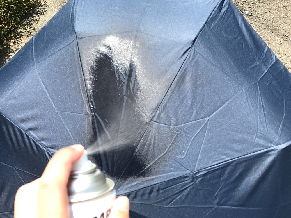 傘に防水スプレーをかけているシーン